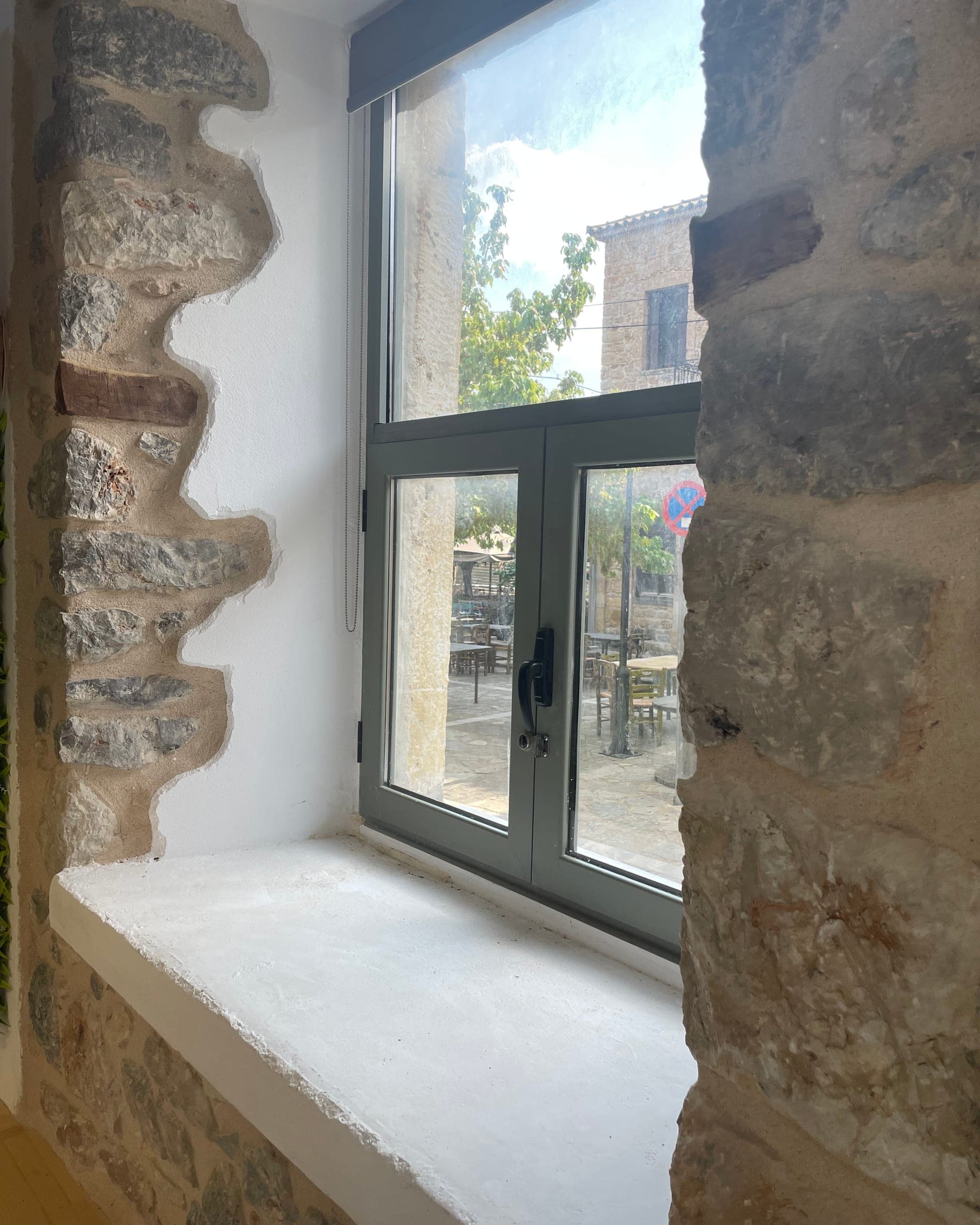 a window onto Kampos main square, with tables under the trees